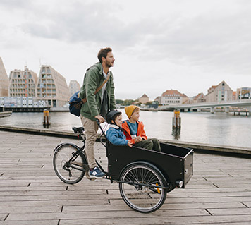 homme sur vélo avec 2 enfants